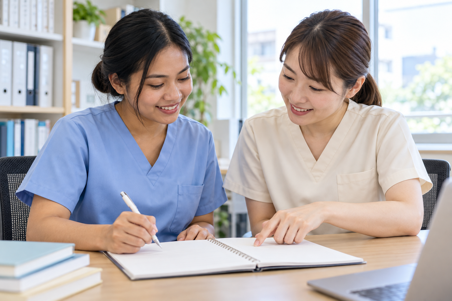 外国人介護職員と教育担当者が練習用ノートで記録の書き方を確認するイメージ